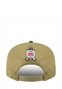 Casquette ajustable vert olive avec un dos en maille, présentant un logo NFL brodé à l'arrière. Tissu lisse avec un motif texturé.