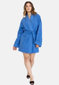 Niebieski lniany szlafrok z szerokimi rękawami, wiązanym w pasie i luźnym kroju. Gładka tekstura z subtelnym połyskiem, długość do połowy uda.