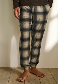 Rudemønstrede bukser i beige og marineblå med elastiske manchetter. Lavet af et blødt stof, med regular fit og sidelommer.