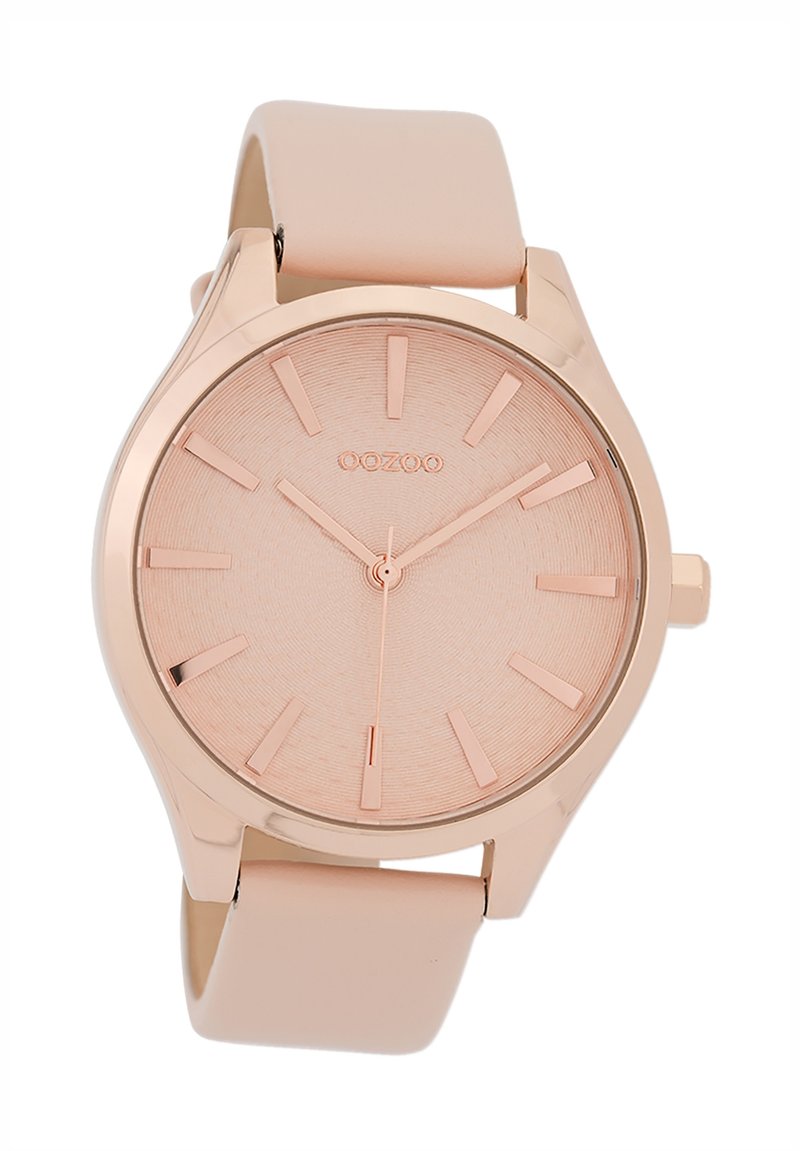 Montre analogique en or rose avec un cadran texturé rose clair, des index en or rose, et un bracelet en silicone rose clair mate.