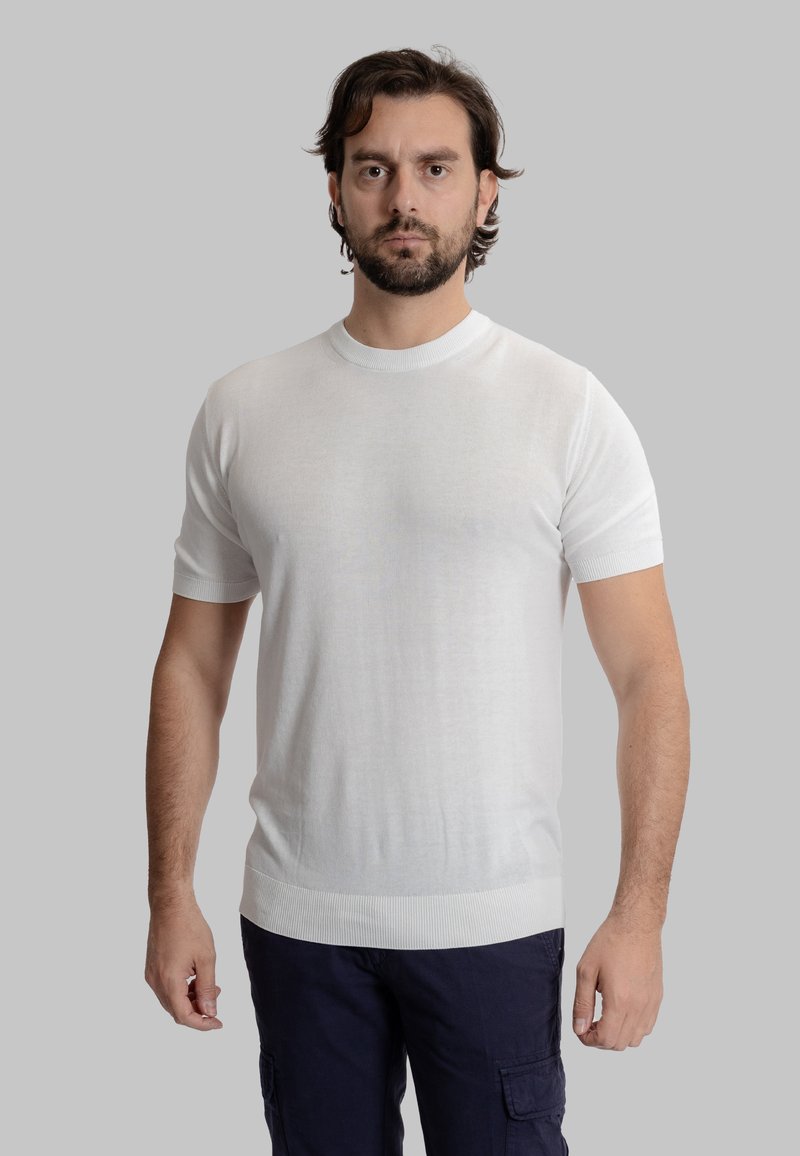 Maglione corto a maniche corte di colore bianco con scollatura rotonda, realizzato in materiale leggero. Presenta dettagli a costine sui polsini e sull'orlo.