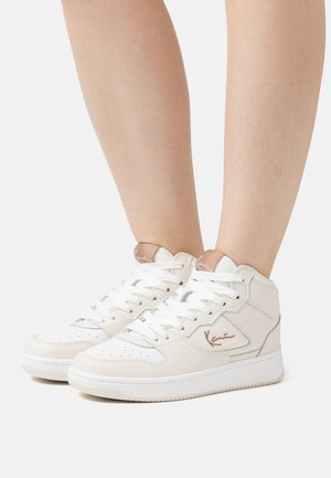 Witte hoge sneakers van leer met vetersluiting, zilveren accenten, geperforeerde neus en een logo-detail aan de zijkant.