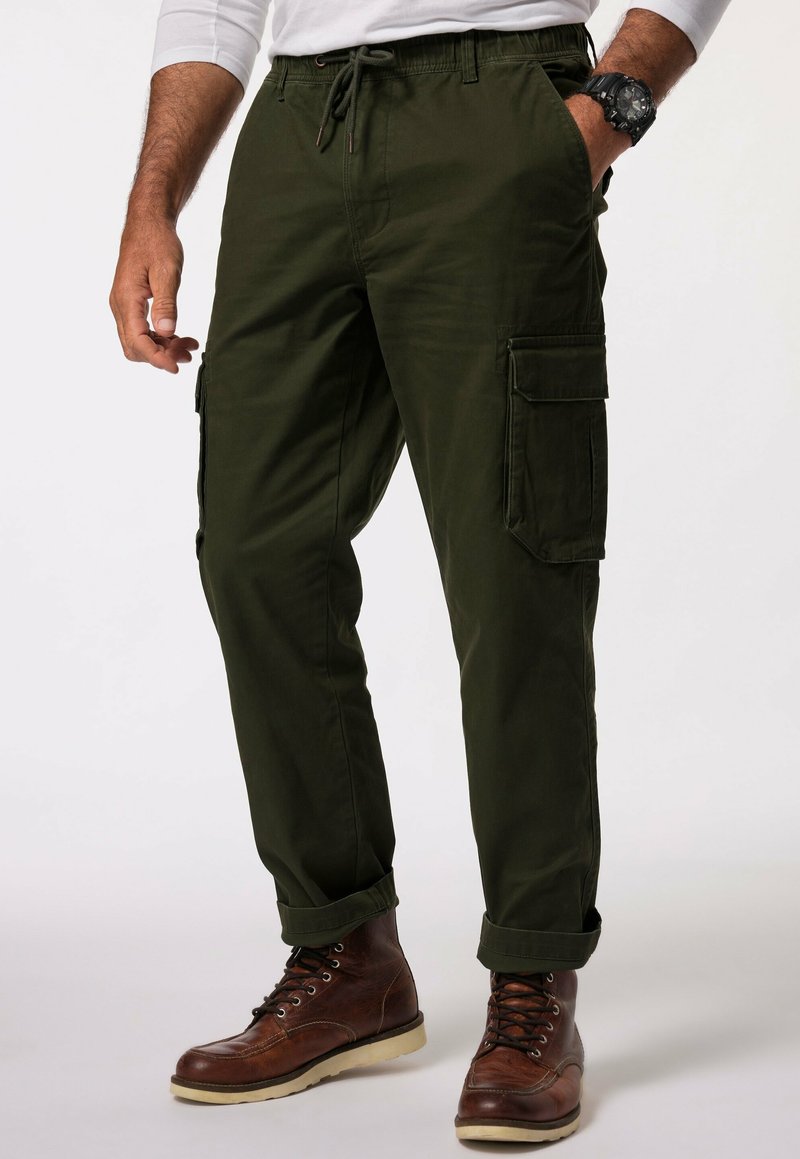 Cargo broek in donkergroen, met een trekkoord in de taille, zijzakken en opgerolde manchetten, gecombineerd met bruine veterboots.
