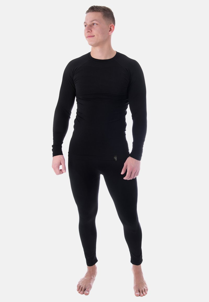Schwarzes langärmeliges Thermaloberteil und figurbetonte Leggings aus dehnbarem Material, mit nahtlosem Design und enganliegender Silhouette.
