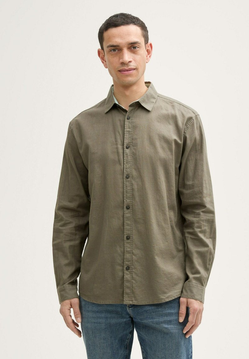 Olijfgroene blouse met lange mouwen en knoopsluiting, gemaakt van een zachte stof, met een klassieke kraag en een getailleerde pasvorm.