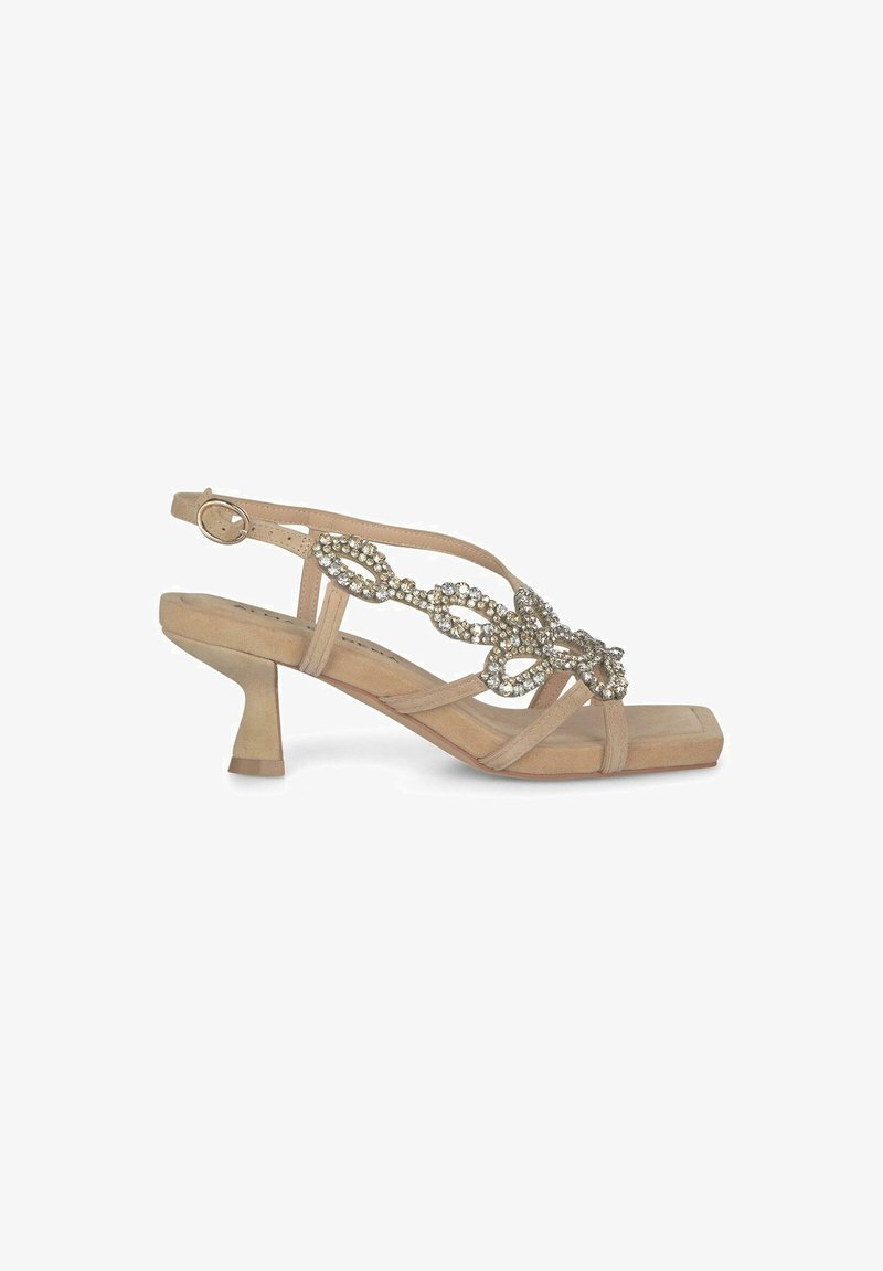 Sandal à talon haut beige avec une bride arriére texturée et des embellissements en cristal. Bout carré et talon en bloc sculpté.