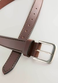 Ceinture en cuir brun avec une boucle en métal argenté, présentant des coutures visibles le long des bords et plusieurs trous pour l'ajustement de la taille.