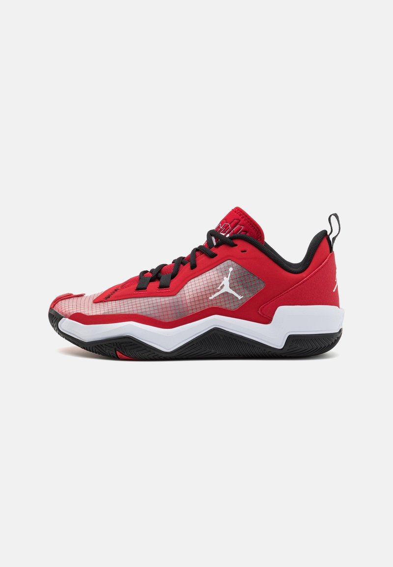 Chaussure de basket basse rouge et noire avec semelle blanche, lacets noirs et logo blanc Jumpman sur le panneau latéral et le talon.