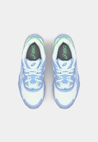 Lyseblå sneakers med hvide detaljer og grønne elementer. Har en tekstureret overdel, rund tå, snørebånd og en polstret sål.
