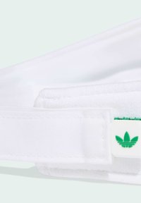 Fehér szövetpánt, amely textúrázott felülettel rendelkezik, zöld Adidas logóval kiemelve. A tervezésbe beletartoznak a varrt szélek és rugalmas anyag.