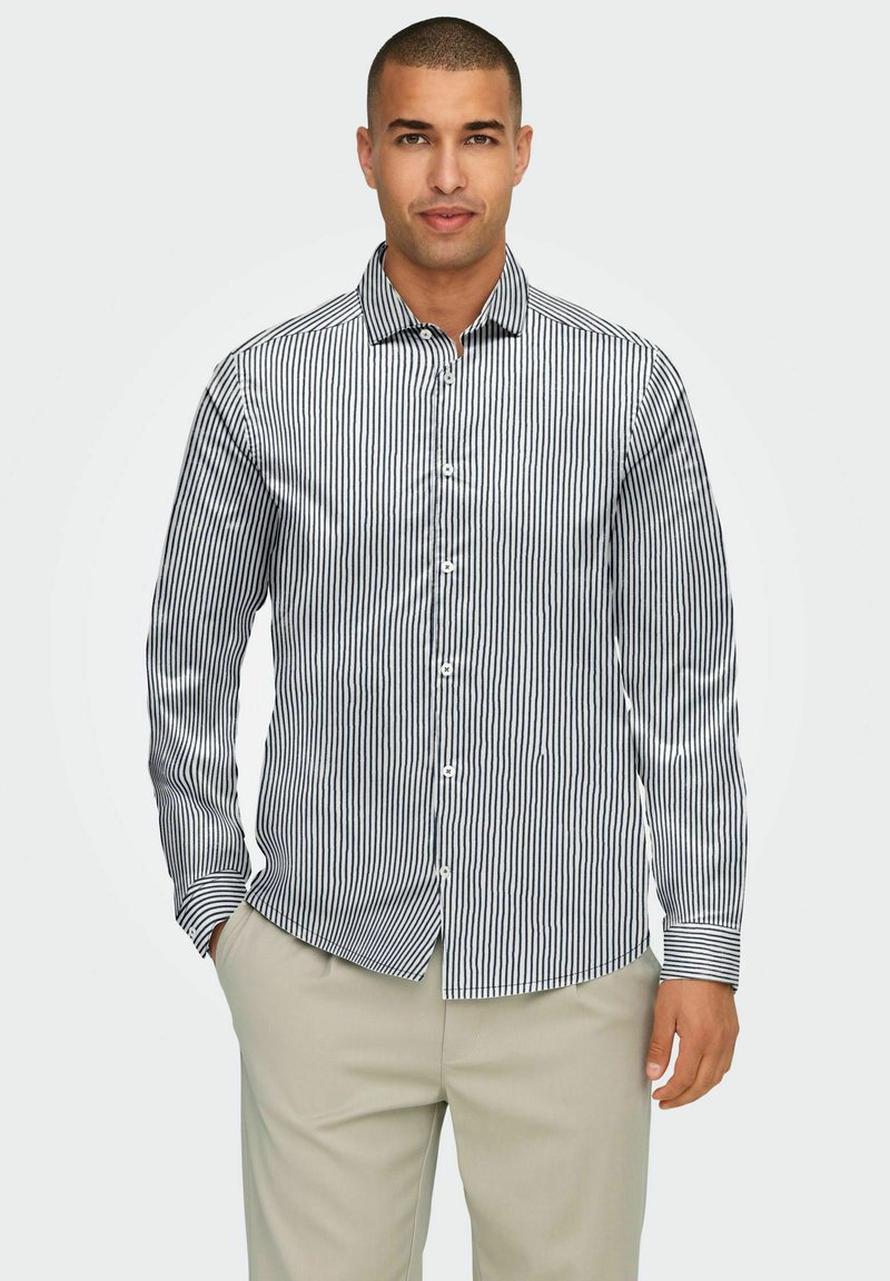 Chemise à boutons avec des rayures verticales bleu marine et blanches, en mélange de coton, col, manches longues et fermeture à boutons.