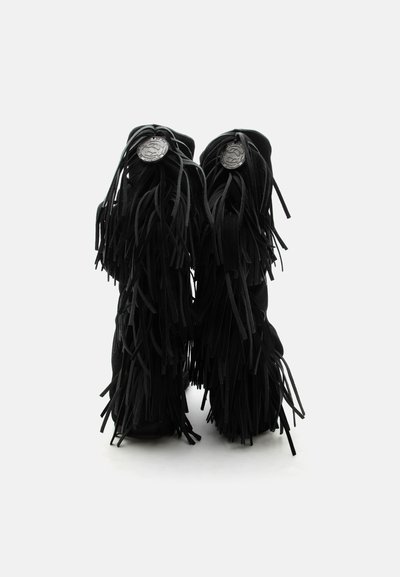 Μαύρα σουέντ μπότες με στρωματοποιημένο κρόσι που καλύπτει την πίσω πλευρά και στρογγυλά ασημί διακοσμητικά κουμπιά κοντά στην κορυφή.