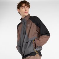 Chaqueta cortavientos en colores negro, gris y marrón, con un alto cuello, cierre de cremallera, puños elásticos y bolsillos frontales con detalles en amarillo.