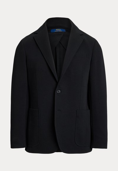 Μαύρο σακάκι με γιακά μικρού γυρίσματος, κλείσιμο με ένα κουμπί, δύο μπροστινές τσέπες και μία τσέπη στο στήθος. Κατασκευασμένο από απαλό ύφασμα με εφαρμοστή γραμμή.