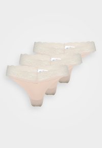 Drie paren lace-trimmed stringetjes in licht perzik, met een zachte stof, golvende kanten tailleband en minimalistisch ontwerp.