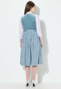 Blauwe bloemenjurk met geplooide zoom, voorzien van een kanten lange mouwen top en een fluwelen lijfje. Inclusief een gestrikte tailleaccent en zilveren hakken.