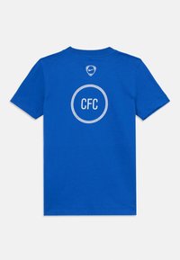 Blå T-skjorte med korte ermer, med hvit "CFC"-tekst inni en prikkete sirkel og liten Nike-logo over på øvre del av ryggen.