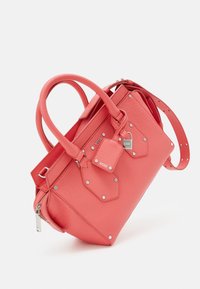 Sac à main en cuir corail avec double poignées, bandoulière réglable, ferrures argentées, coutures visibles et accents hexagonaux à l'avant.