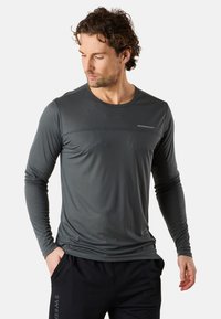 Langärmliges Sportshirt in Dunkelgrau, mit glatter Textur, subtilen horizontalen Streifen und einem kleinen Logo auf der Brust.