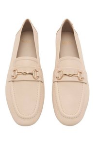 Beige nahka loaferit pyöreällä kärjellä, tikkausyksityiskohdilla ja kultaisella varusteella edessä. Pehmeä rakenne ja minimalistinen muotoilu.
