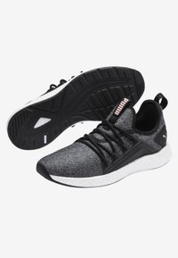 Baskets de sport noires et grises avec une tige texturée, une semelle intermédiaire blanche et une semelle extérieure en caoutchouc noir. Comprend des lacets et un logo Puma.