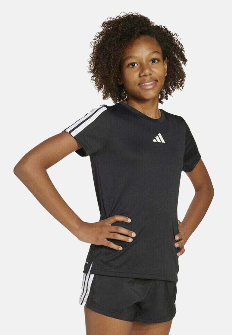 Maglietta sportiva nera a maniche corte, logo Adidas bianco sul petto e tre strisce bianche sulle spalle; abbinata a pantaloni corti neri.