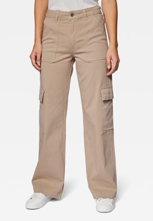 Beige cargo pants with wide legs, multiple side pockets, front button closure, and made of durable fabric. Worn with white sneakers.