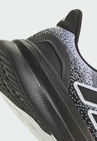 Black and gray athletic shoe featuring textured mesh upper, a patterned sole, and contrasting accents. Design emphasizes grip and support.