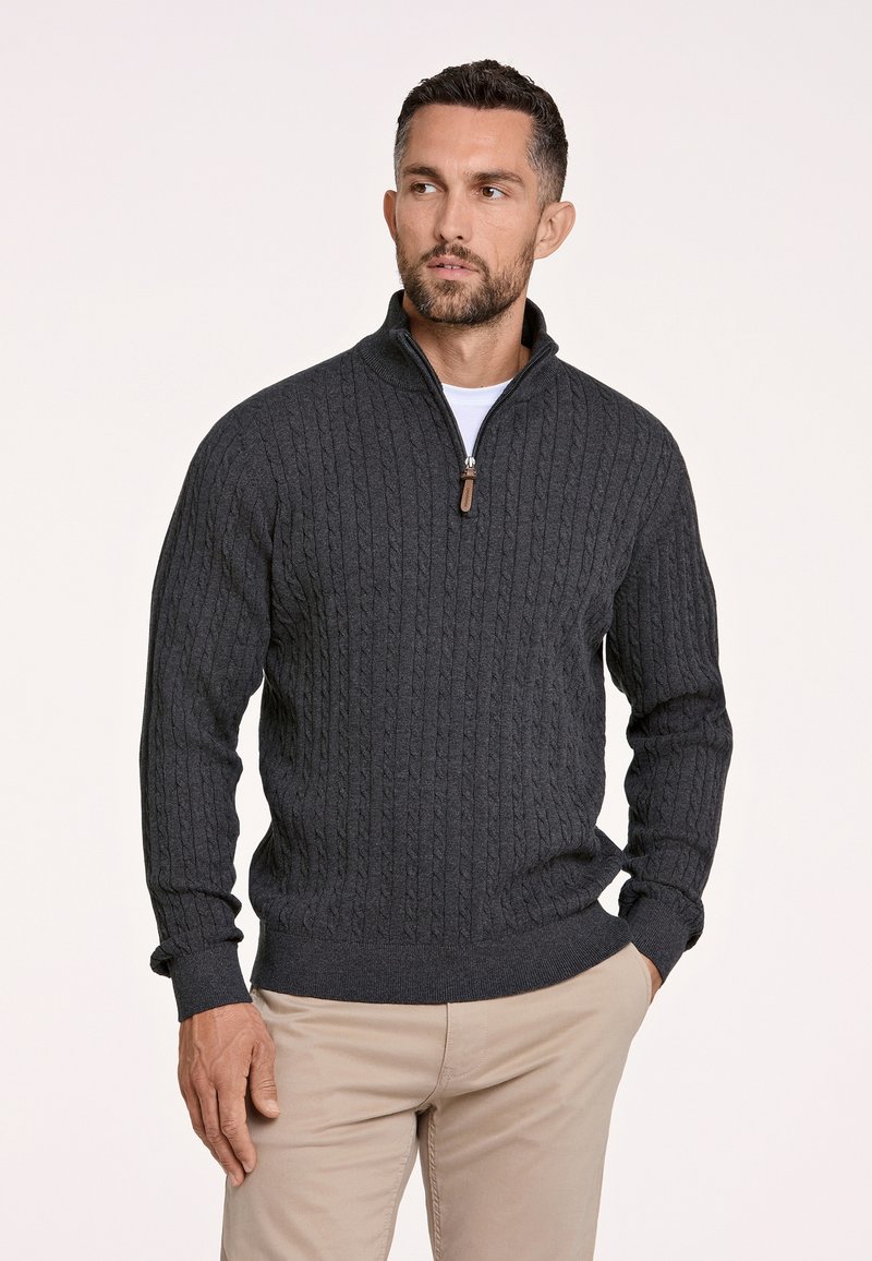 Dunkelgrauer Strickpullover mit einem Reißverschlusskragen, der ein strukturiertes Zopfmuster aufweist. Rippbündchen und -saum heben das Design hervor. Über einem weißen Hemd getragen.