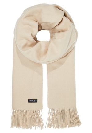 Beige zachte sjaal met franjes aan de uiteinden, in een lus gewikkeld, met een klein zwart label met merknaam nabij de onderrand.