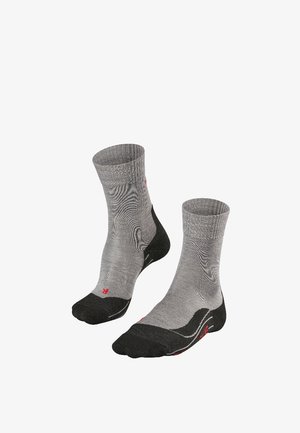 Calcetines deportivos grises con un tejido texturizado, con acentos en el dedo del pie y el talón en negro, puños acanalados y un sutil logo rojo en el costado.