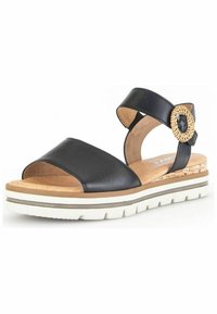 Sandale en cuir noir avec deux larges sangles et une boucle tressée décorative. Comprend une semelle en liège et une semelle blanche rembourrée pour le confort.