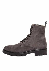 Bottine en daim gris avec un bout arrondi, un laçage à l'avant et une semelle en caoutchouc. Elle présente des accents de coutures et une languette à l'arrière.