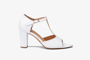 Sandalias de tacón alto blancas con punta abierta y diseño de tira en T. Fabricadas en cuero suave, con un hebilla dorada y un tacón grueso.