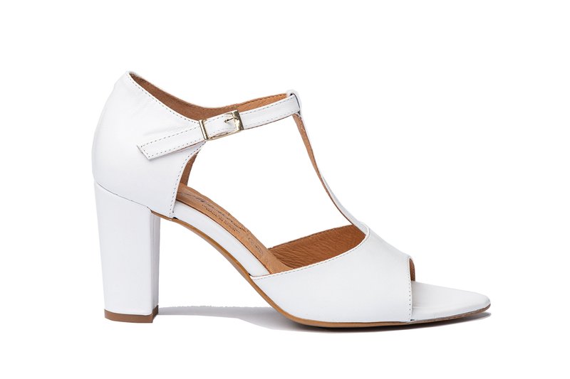 Sandalias de tacón alto blancas con punta abierta y diseño de tira en T. Fabricadas en cuero suave, con un hebilla dorada y un tacón grueso.