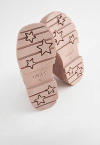 Roosad kingan나라 pealsud, tähtekujuline muster, suurus 6, brändi nimi "NEXT" sisse pressitud igale pealsul, valge taust. 