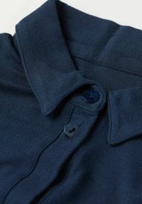 Mörkblå polo skjorta med mjukt tyg, en vikbar krage och två matchande knappar på placket, som framhäver en slät textur.