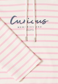 Tissu rayé blanc et rose avec une manche et le texte imprimé "Curious Memories and Maps", partiellement recouvert par des cordons blancs munis d'embouts métalliques.