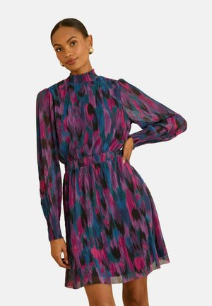 Plisserad klänning med hög hals, långa ärmar och markerad midja i ett mångfärgat abstrakt mönster med nyanser av rosa, blått och svart.