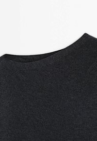 Gros plan d'un tissu tricoté gris foncé avec un col arrondi, montrant une texture côtelée fine et des coutures serrées.