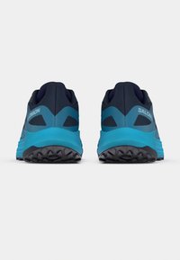 Chaussures de trail avec une tige bleu foncé et des accents turquoise, une semelle extérieure en caoutchouc texturé, et un talon renforcé pour le soutien.