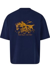 Camiseta de algodón azul marino de corte relajado. Presenta un diseño gráfico naranja de caballos y texto en la parte trasera. Mangas cortas y cuello redondo.