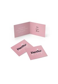 Biglietto d'auguri rosa con testo in bianco e nero. All'interno, un'area per il messaggio con righe per scrivere. Include due biglietti più piccoli con la scritta "Danke."