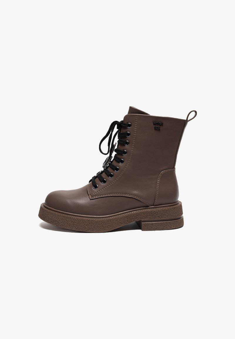 Bottines en cuir marron avec lacets noirs, bout rond et semelle plateforme texturée. Elles disposent d'un tirant à l'arrière pour un enfilage facile.