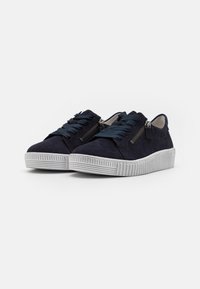 Navy suede sneakers with contrasting gray rubber sole, round toe, flat laces, and decorative zipper on the side for added detail.