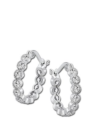 Boucles d'oreilles en argent en forme de créole avec un design en vagues, ornées de pierres transparentes rondes disposées uniformément autour du bord extérieur.