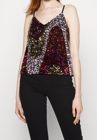 Camisola con paillettes a V, caratterizzata da un motivo multicolore di paillettes dorate, rosa e nere. Le spalline sono sottili e nere.