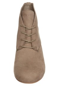 Scarpa taupe con lacci, caratterizzata da una superficie liscia simile alla suede, punta arrotondata e dettagli di cucitura minimi. Nome del brand impresso sul tallone.