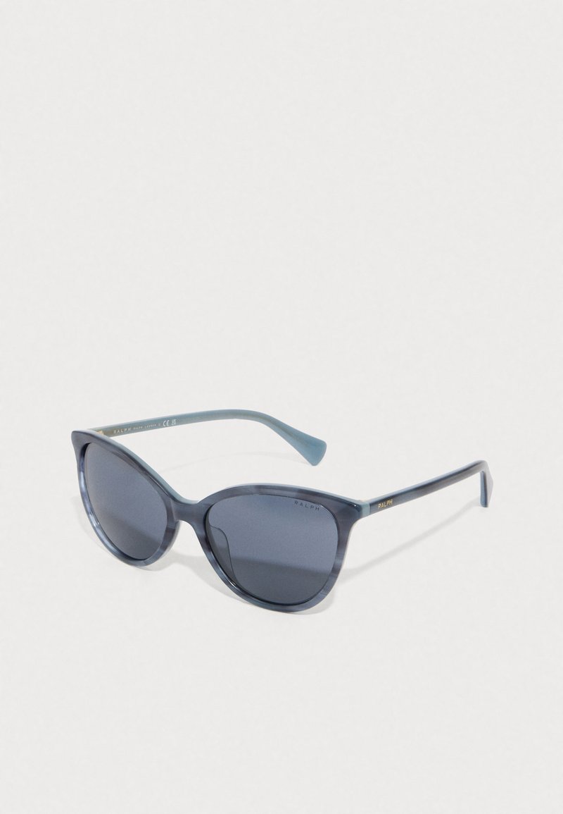 Óculos de sol estilo gato com uma armação azul semi-transparente, lentes cinzentas e hastes azul claro. Apresenta um logotipo discreto na parte interna da haste.