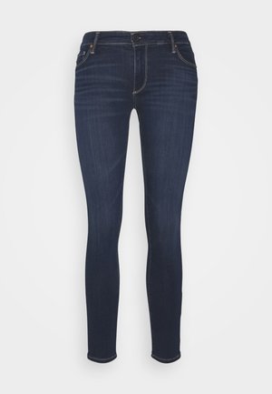 Tumman siniset kapeat farkut, jotka on valmistettu denimistä, sisältävät klassisen viiden taskun suunnittelun ja beigeommelta, sekä sujuvan pinnan ja slim fit -leikkauksen.